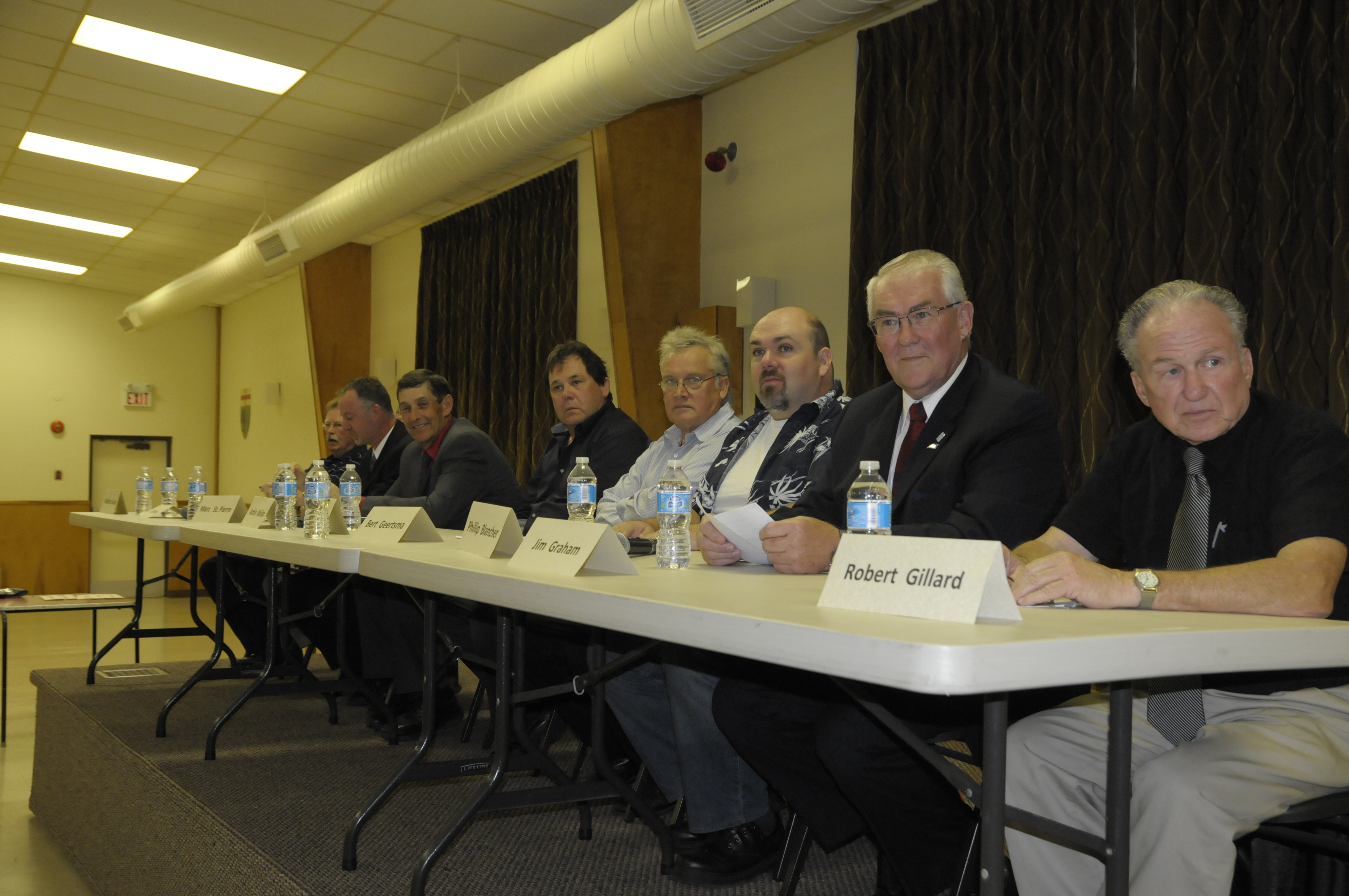 Running for councillor in South Dundas are (from left) Mahlen Locke, Bill Ewing (not shown), Marc St. Pierre, Archie Mellan, Jim Mills, Bert Geertsma, Phillip Blancher, Jim Graham and Robert Gillard. They were taking questions from the audience during the all candidates debate at Matilda Hall Oct. 14 (Cornwall Newswatch)