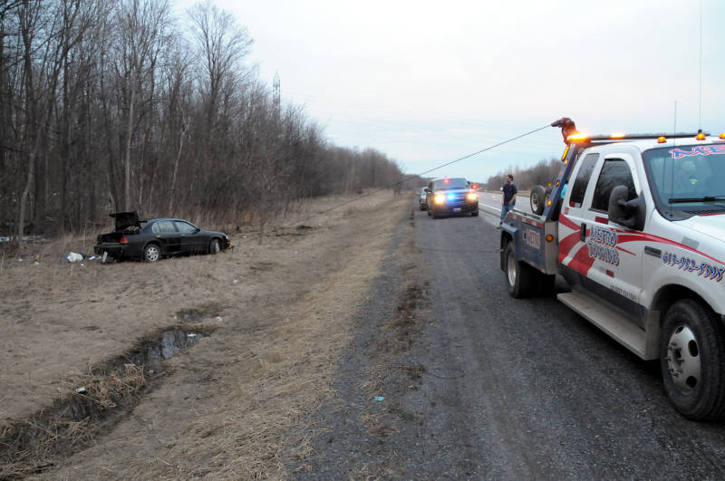 A tow truck starts pulling this car out of the ditch on the westbound Highway 401 in South Stormont after a single vehicle crash on April 3, 2015. (Cornwall Newswatch/Bill Kingston)