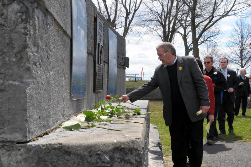 Cornwall, Ont. mayor Leslie O'Shaughnessy places a red rose on the Workers' Memorial in Lamoureux Park as part of the National Day of Mourning for killed and injured workers. (Cornwall Newswatch/Bill Kingston)