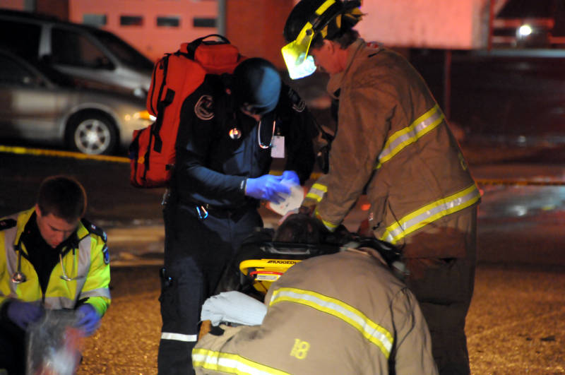 A Cornwall firefighter performs chest compressions on a fire victim while a paramedic performs his duties while waiting for an ambulance to get into position to load the patient after a multiplex fire on Sixth Street West on April 3,2015. (Cornwall Newswatch/Bill Kingston)