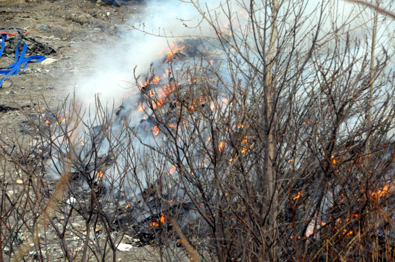 Flames dart between piles of garbage in the Cornwall landfill April 18, 2015. It's not known what started the fire which kept firefighters on scene for several hours and taxed their resources. (Cornwall Newswatch/Bill Kingston)