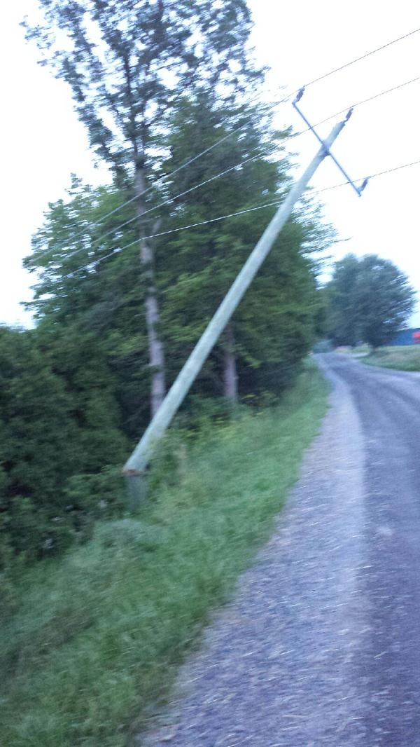 A hydro pole on Heron Road, west of Williamstown, Ont., is snapped off at the base, a likely cause of a massive outage in South Glengarry July 14, 2015. Hydro One doesn't expect to have the power back on until 2 a.m. July 15, 2015. (Photo/Bryan Ward)