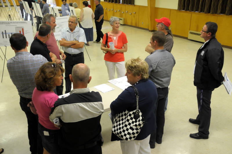 South Dundas councillors and staff, spokesmen from EDP Renewables and local residents chat about the proposed South Branch Wind Farm II project during an open house Aug. 5, 2015 at Matilda Hall in Dixons Corners. (Cornwall Newswatch/Bill Kingston)