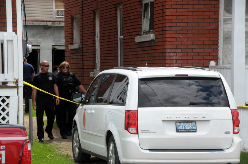 Cornwall Fire Prevention Officer Terry Lauzon leads a city police officer from the back of this apartment building at 711 First Street East on Aug. 22, 2015. Fire officials say no one was in the building during a morning fire. (Newswatch Group/Bill Kingston)