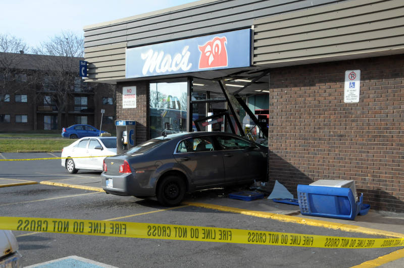 A sedan plows through the front of a Mac's convenience store in Cornwall, Ont. on Dec. 6, 2015. Two people in the vehicle were checked over by paramedics as a precaution. Police say nobody inside the store was hurt, (Newswatch Group/Bill Kingston)