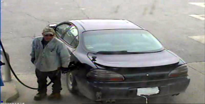 In this Monday, April 18, 2016 photo provided by SD&G O.P.P., plastic bags cover the licence plate of a car as a man fuels up at the Monkland Esso. The suspect is wanted for stealing fuel from the gas station on Highway 138. (SD&G O.P.P. via Newswatch Group)