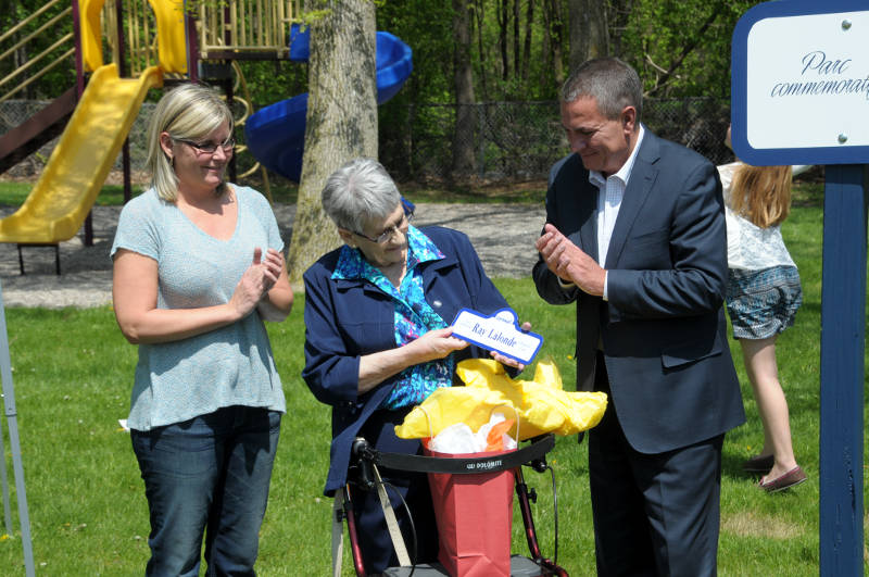 Members of the Lalonde family open a gift from the city Friday, May 20, 2016 during the dedication of a Glenview Heights park as Ray Lalonde Memorial Park. Vicki Lalonde, Merita Lalonde and Todd Lalonde receive a keepsake sign. (Newswatch Group/Bill Kingston)