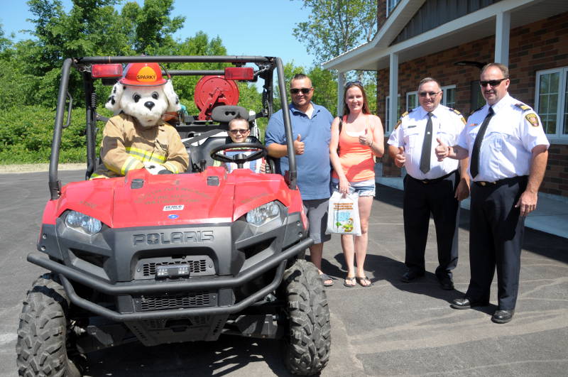 Lhandon Heagle-Francis (seated on the ATV with Sparky) is recognized for spotting a fire on County Road 2 in May that likely saved the home from serious damage. Pictured are Sparky, Lhandon Heagle-Francis, father Justin Francis, mom Khrista Heagle-Francis, South Glengarry Deputy Chief Gabriel McEvoy and Assistant Deputy Chief Brian Poirier. (Newswatch Group/Bill Kingston)