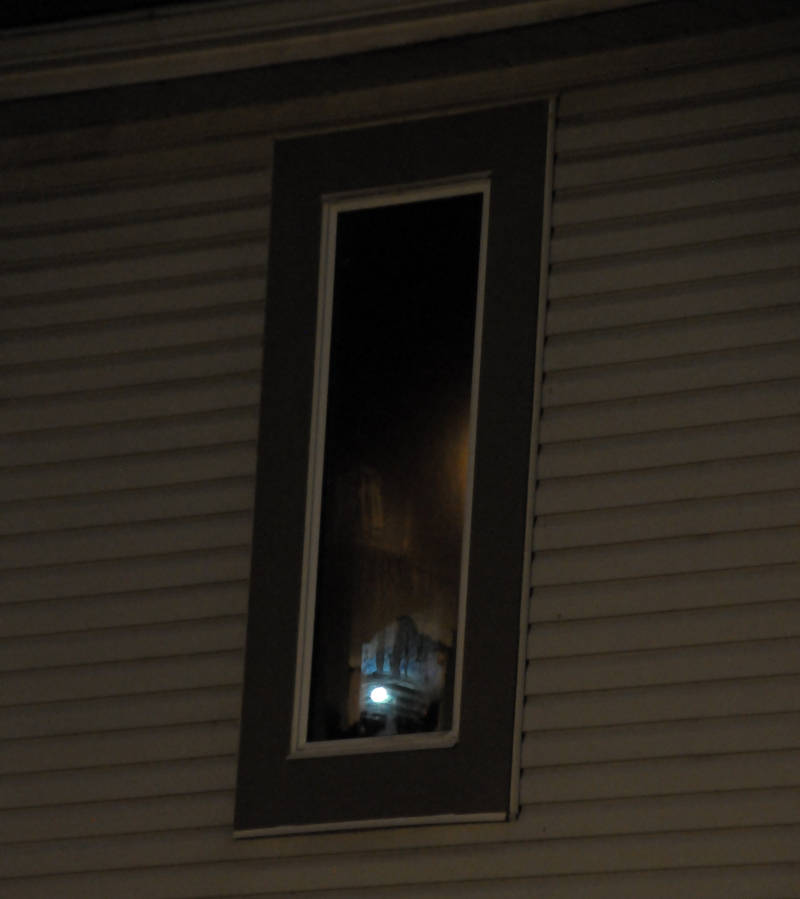 A Cornwall firefighter's flashlight reflects off a soot-covered bedroom window Monday, July 18, 2016 after a fire in a child's closet at a townhouse on Lemay Street in Cornwall, Ont. Two people in the unit were able to escape uninjured. (Newswatch Group/Bill Kingston)
