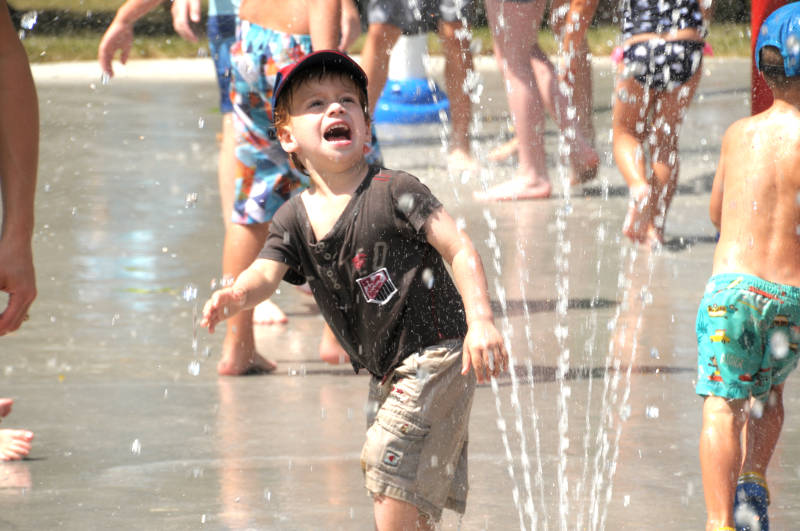 Byron Rohde, 3, runs away from a sprinkler at the splash pad in Riverdale Park, shortly after its opening Friday, Aug. 5, 2016. (Newswatch Group/Bill Kingston)